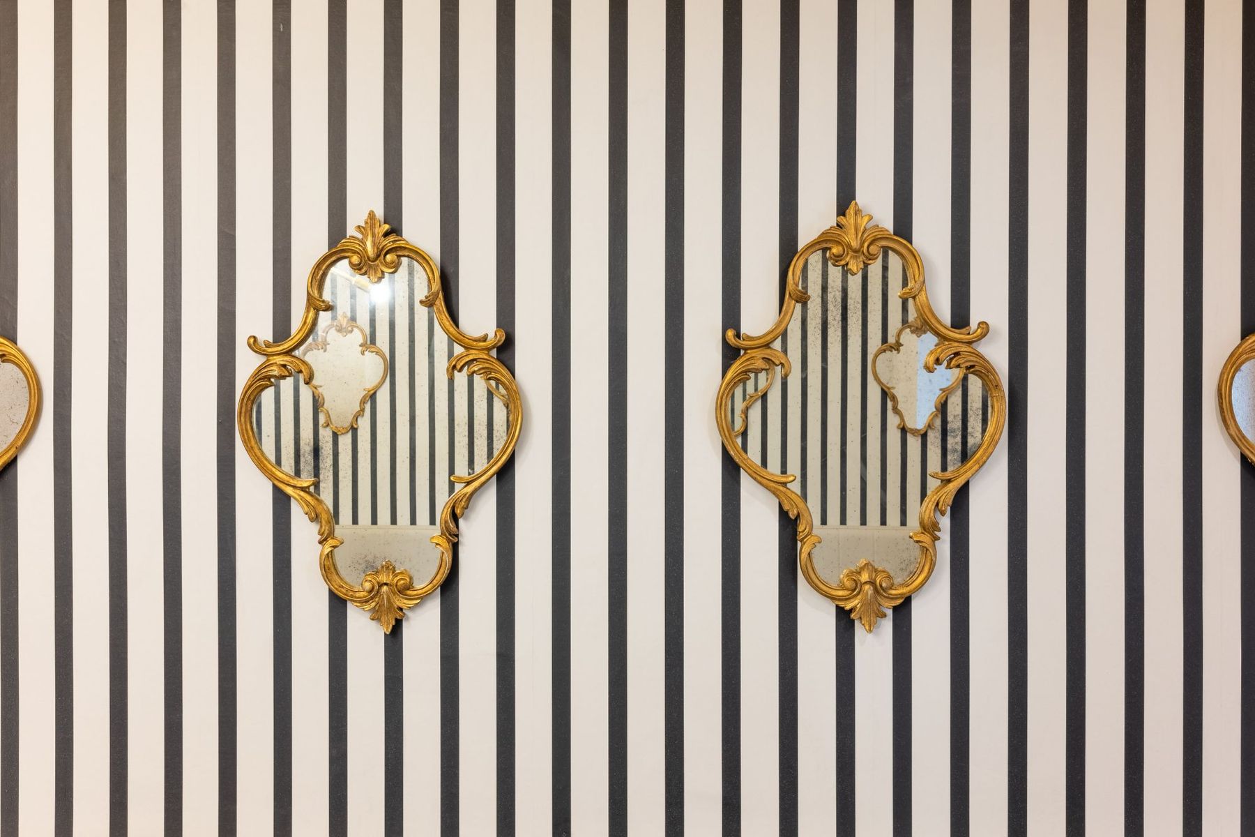 Sala colazioni con righe bianche e nere e specchi decorati