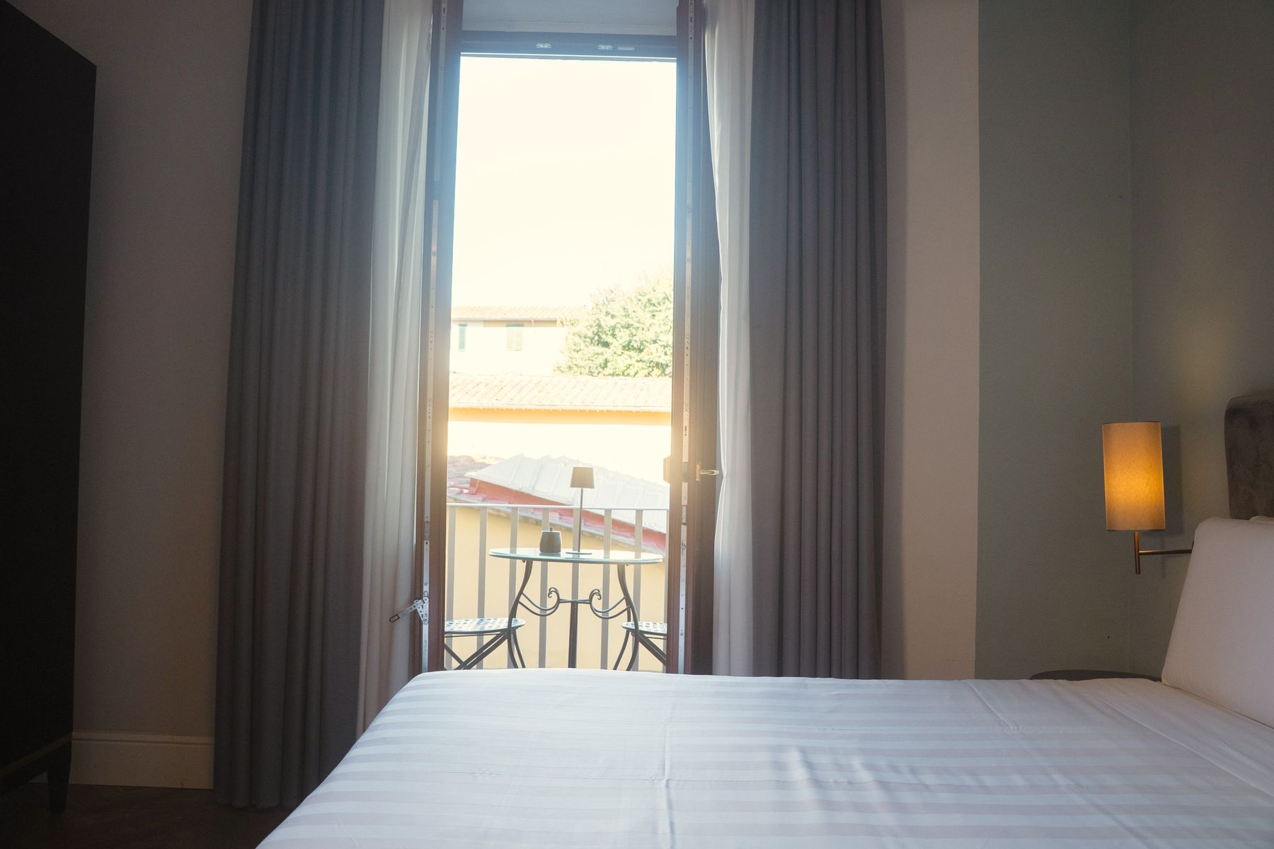 Camera Superior — porta finestra sul balcone con tende